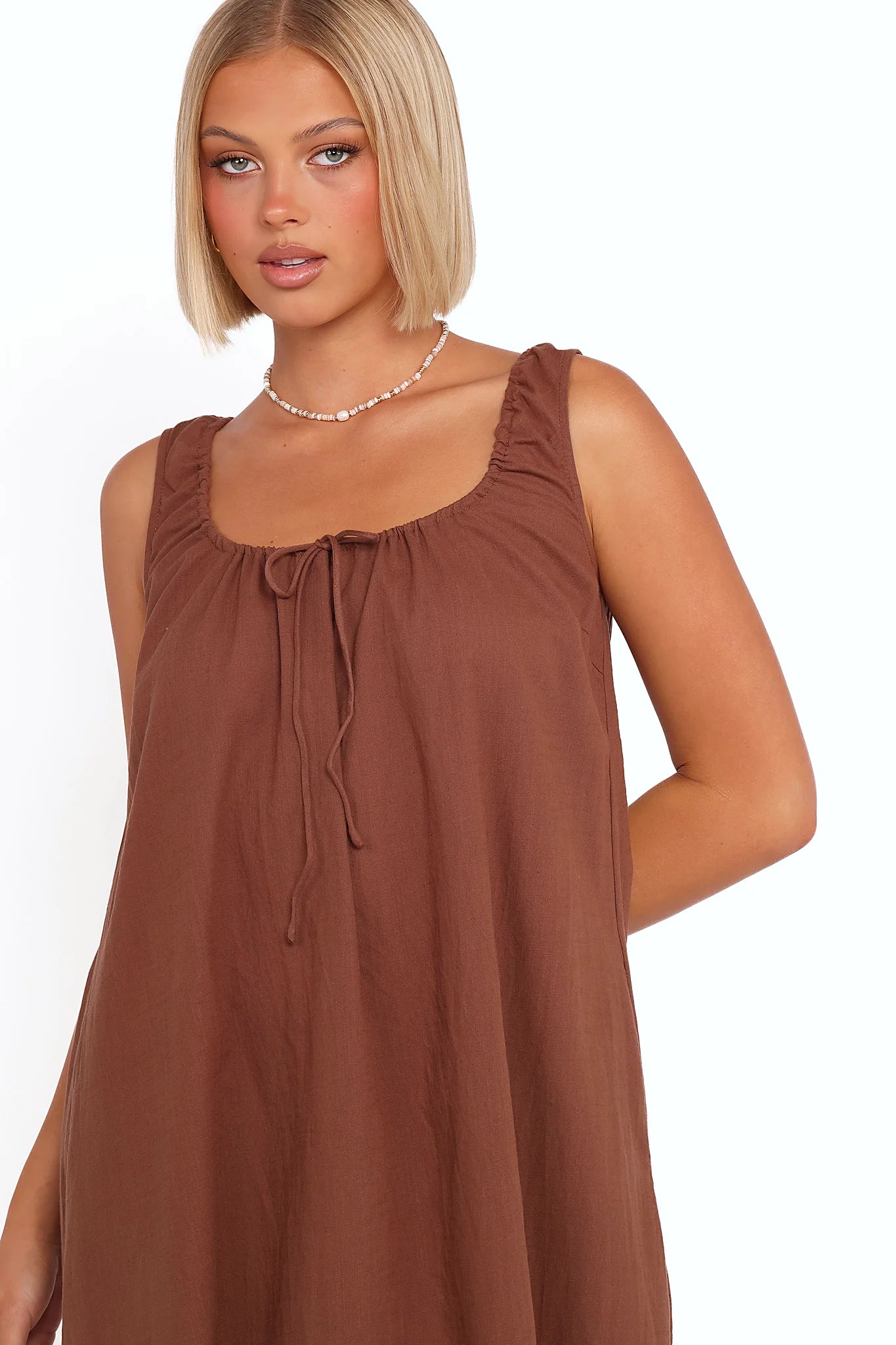 Side view showing the drape of the chocolate brown tie-front maxi dress