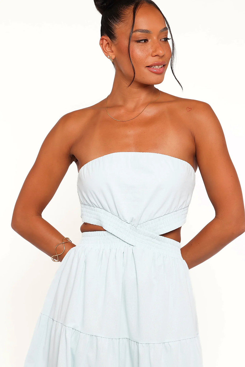 Side view showing the drape of the blue strapless maxi dress