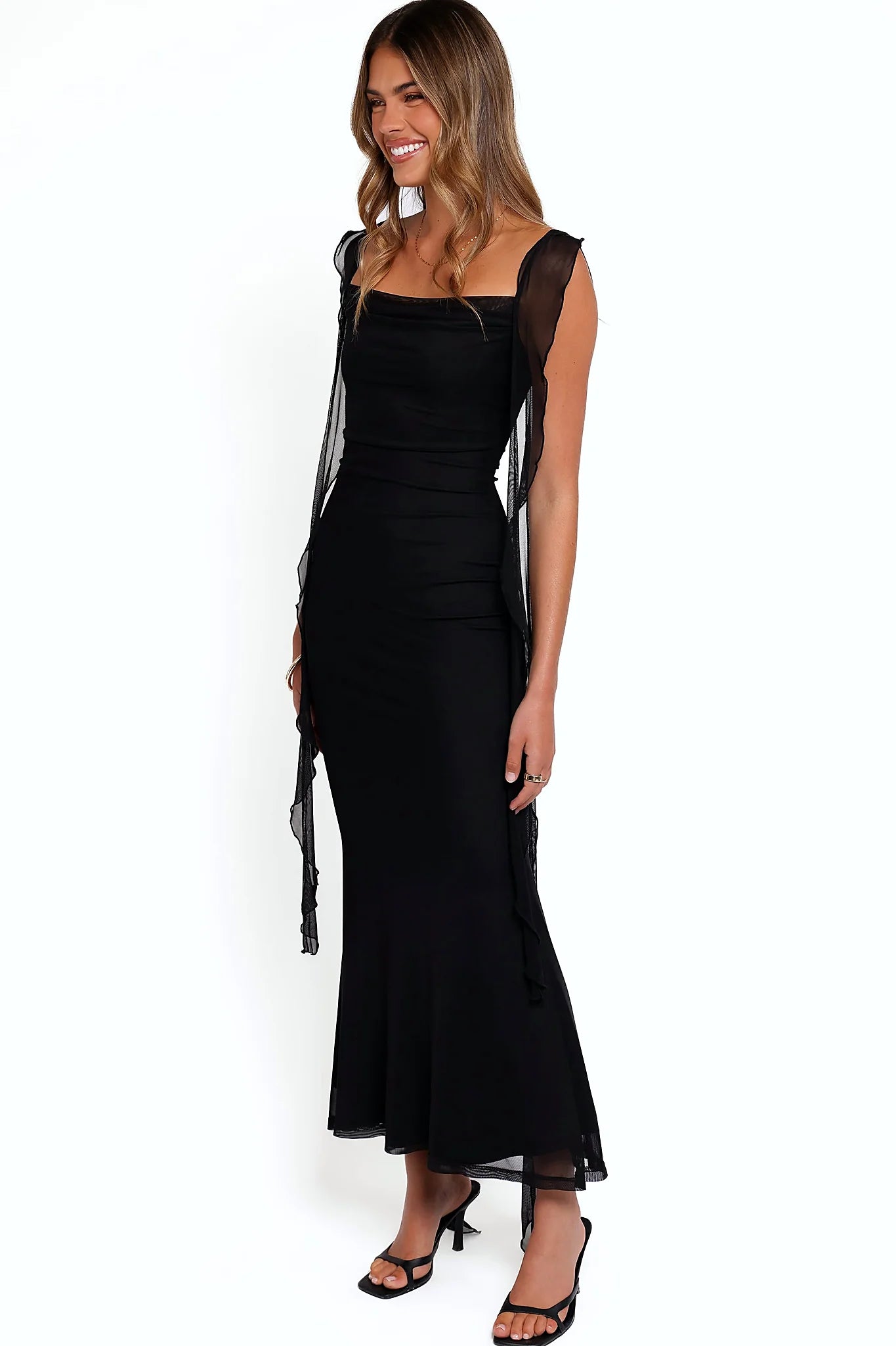 Back view of the black ruffle-strap maxi dress on a model
