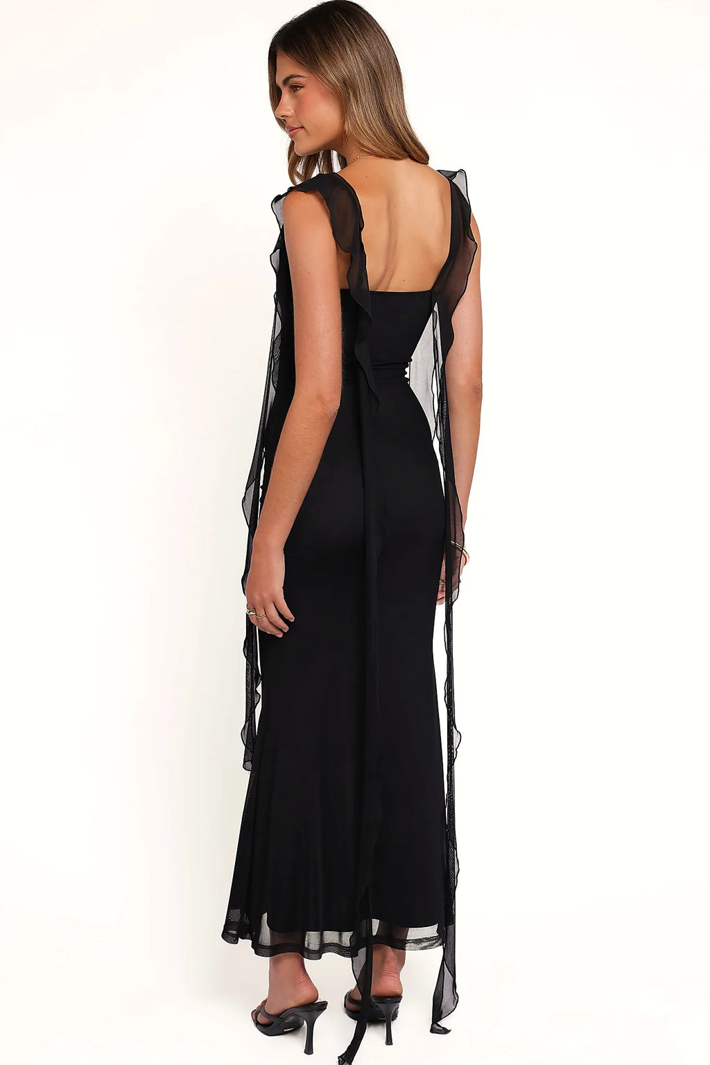 Side view showing the drape of the black ruffle-strap maxi dress