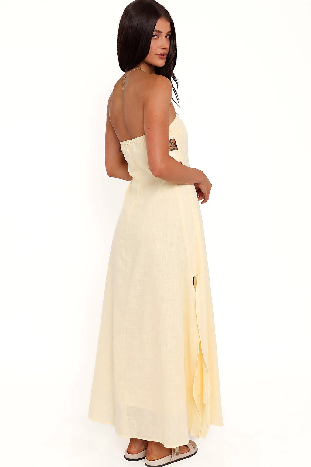 Side view showing the drape of the butter yellow strapless maxi dress