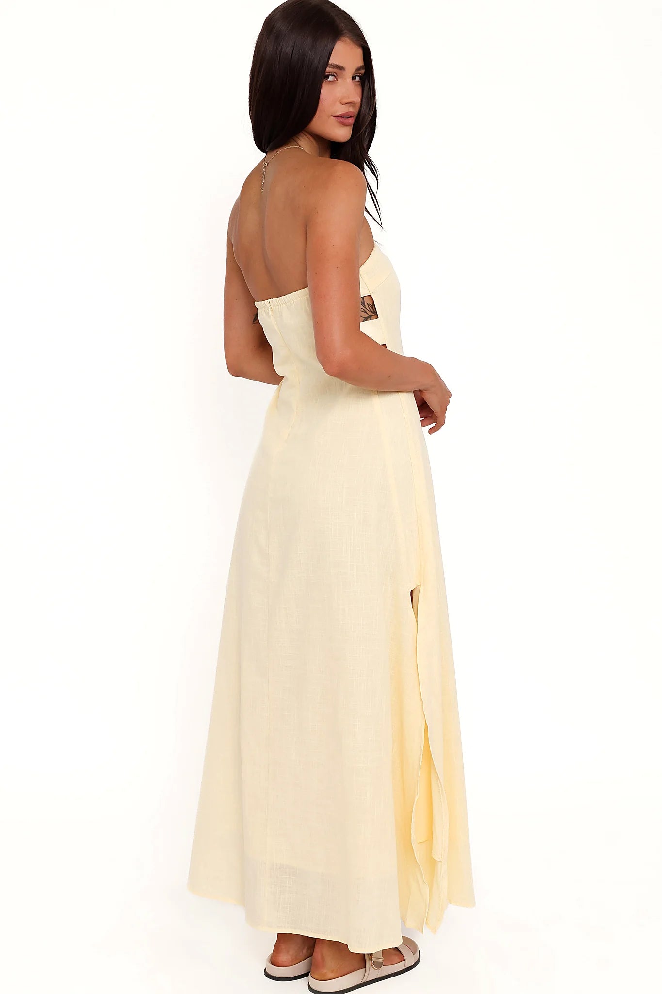 Side view showing the drape of the butter yellow strapless maxi dress