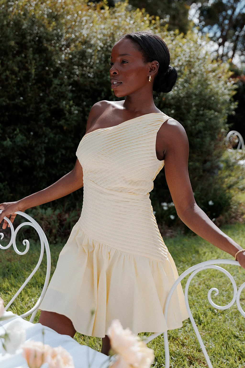 Side view showing the drape of the butter yellow off-shoulder mini dress