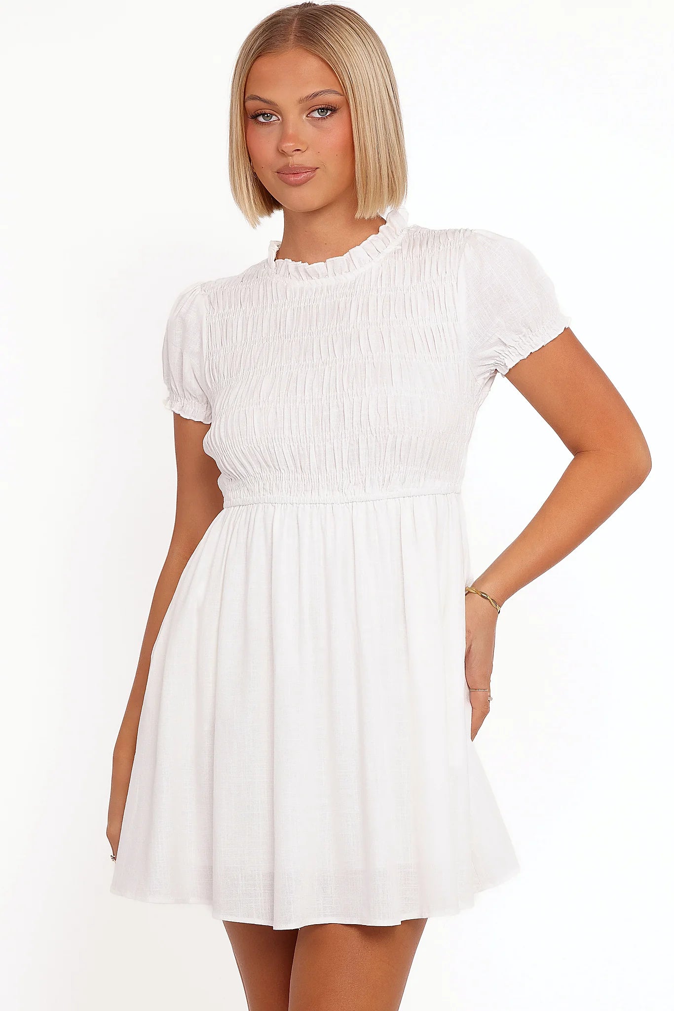 Model wearing the white puff-sleeve mini dress, front view