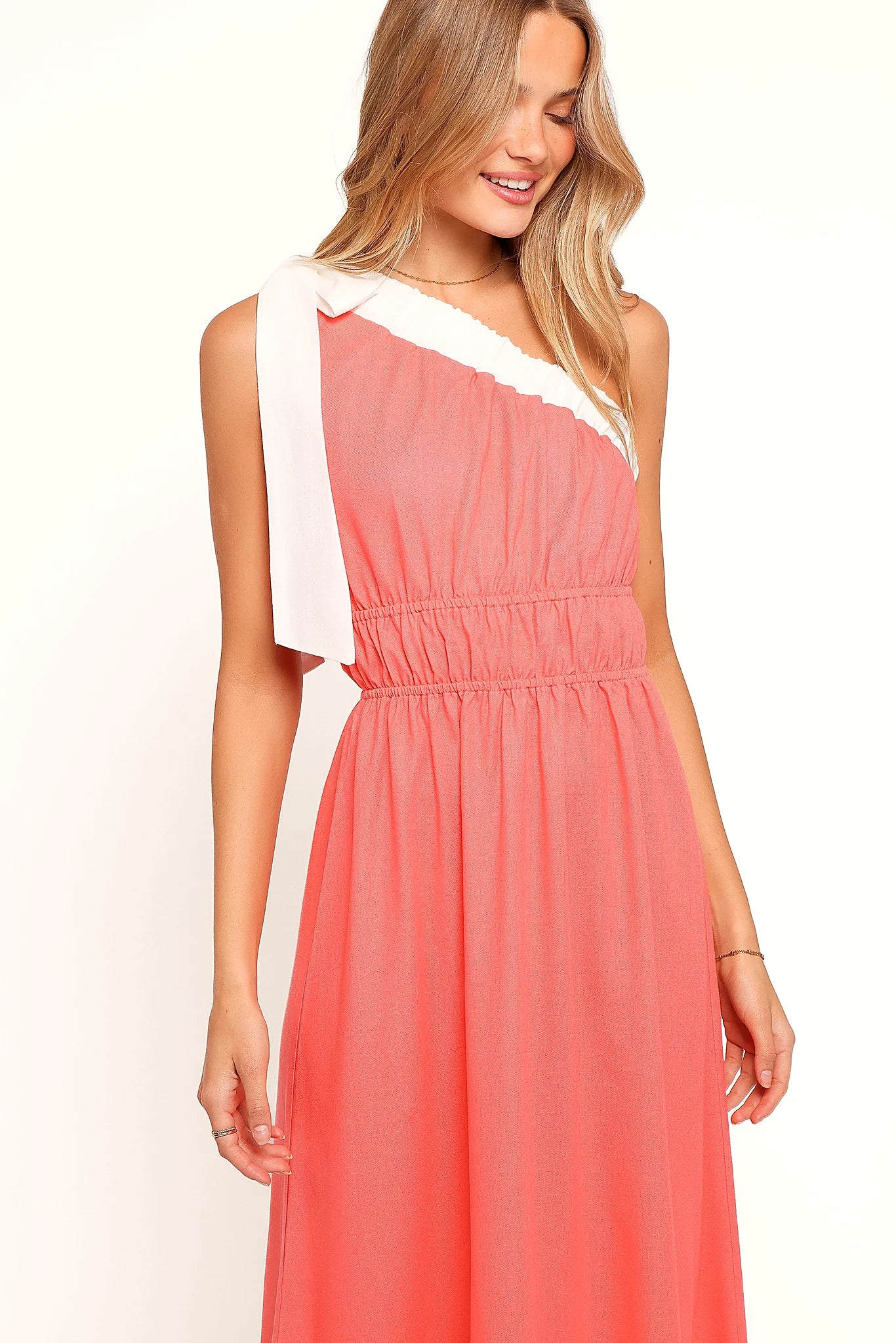 Model wearing the coral one-shoulder maxi dress, front view