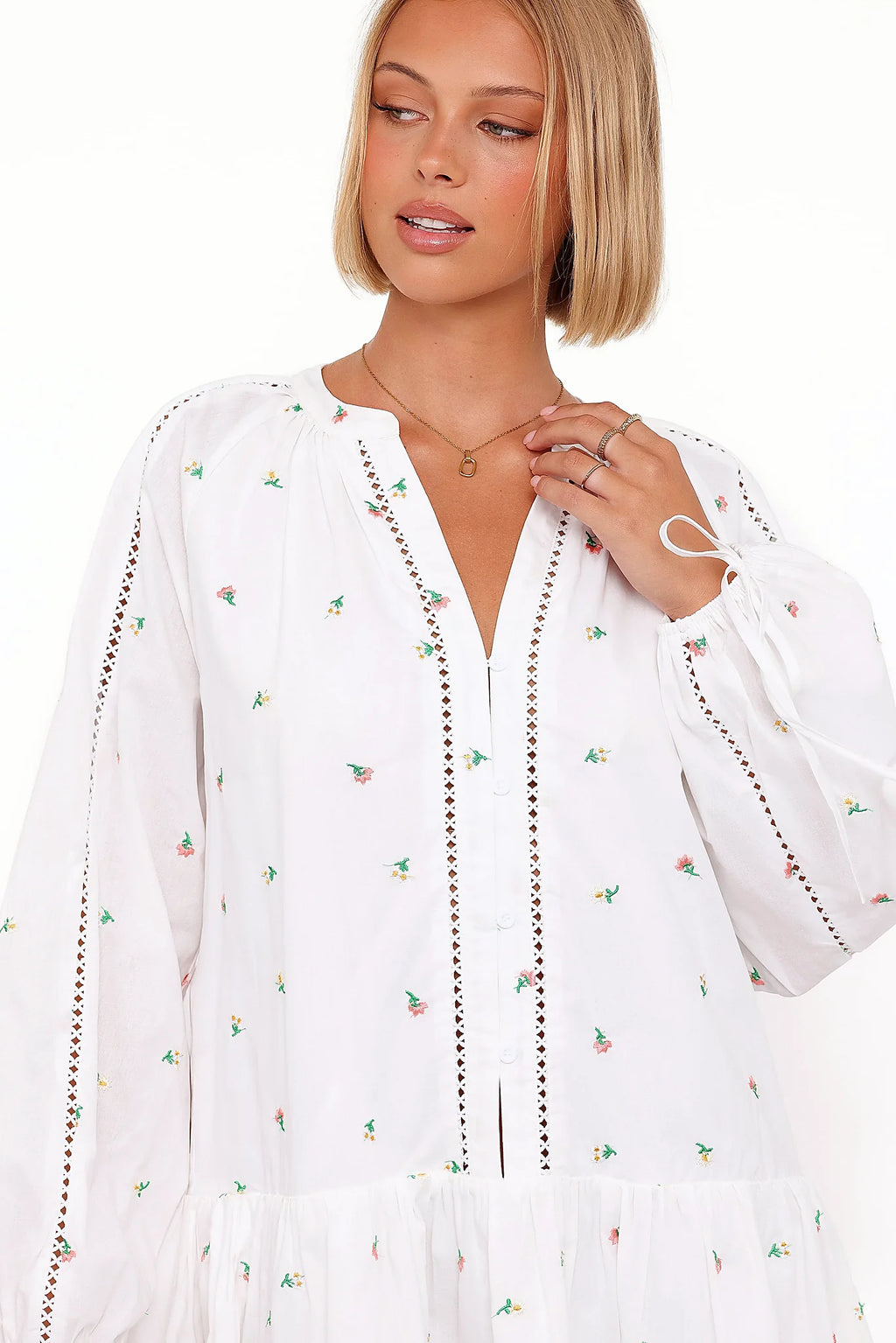 Detail view of the white embroidered floral mini dress