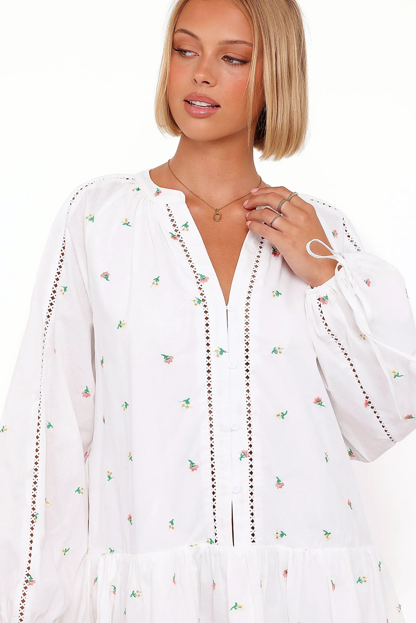 Detail view of the white embroidered floral mini dress