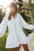 Side view showing the drape of the white embroidered floral mini dress