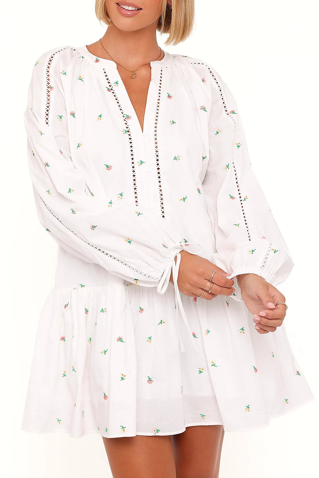 Full-length view of the white embroidered floral mini dress