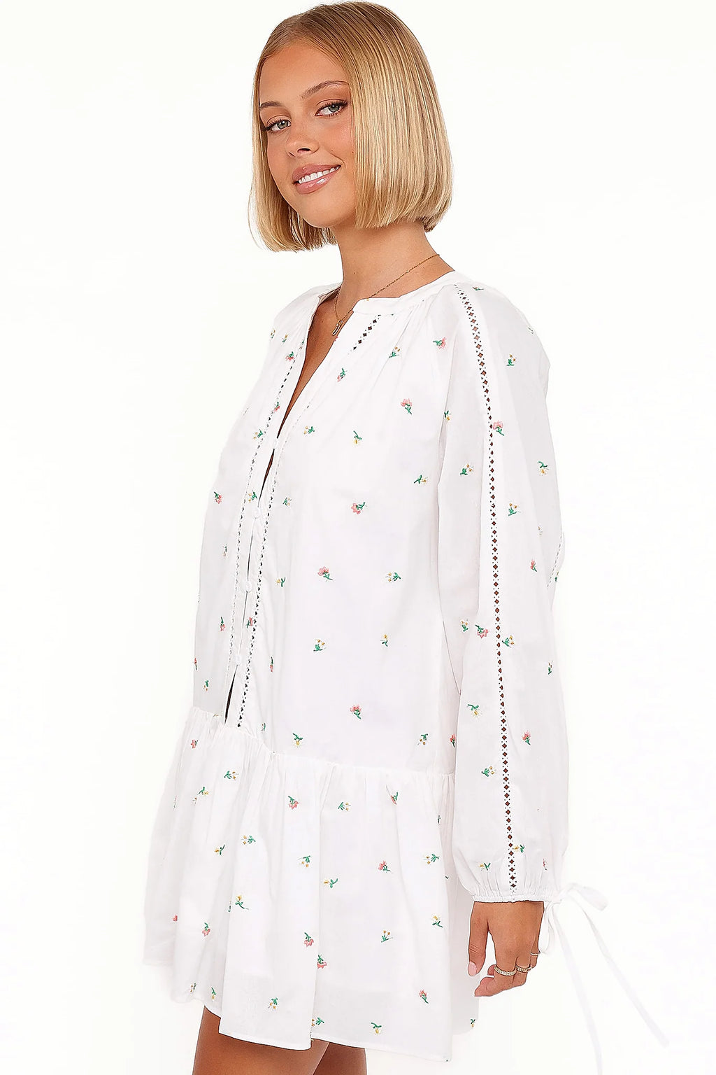 Close-up of the neckline of the white embroidered floral mini dress