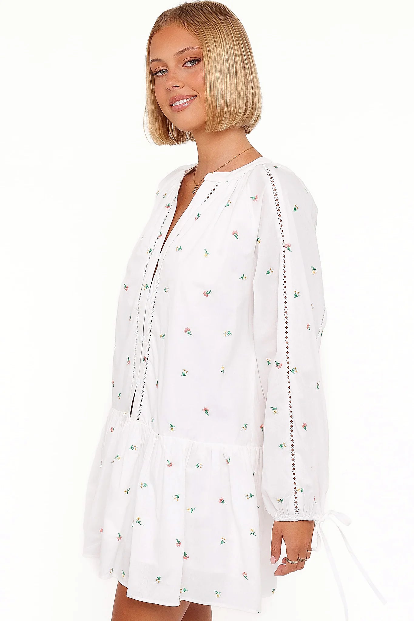 Close-up of the neckline of the white embroidered floral mini dress
