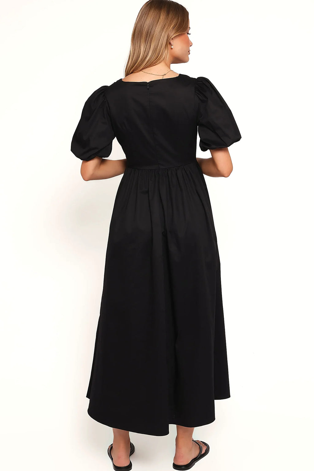 Back view of the black empire waist maxi dress on a model