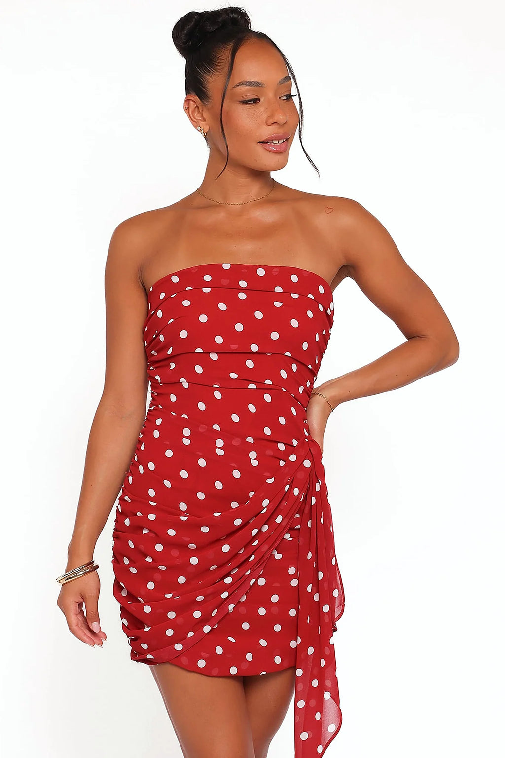 Close-up of the neckline of the red polka dot strapless mini dress