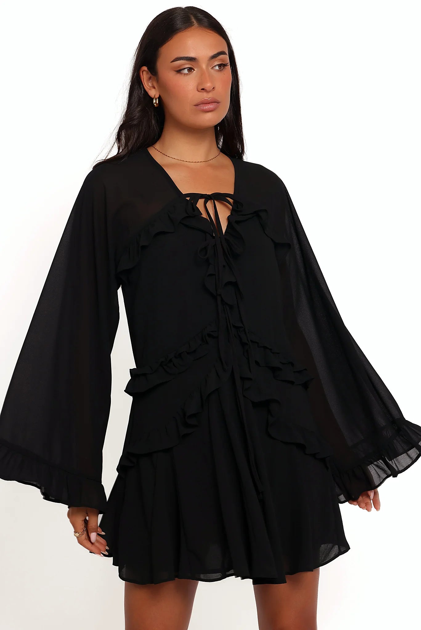 Model wearing the black flare-sleeve mini dress, front view