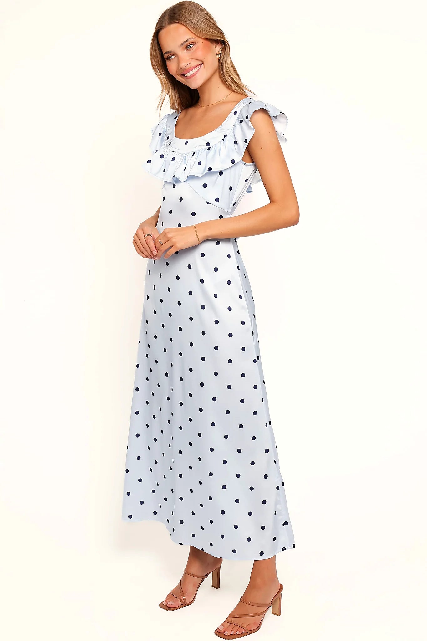 Back view of the blue polka dot off-shoulder maxi dress on a model
