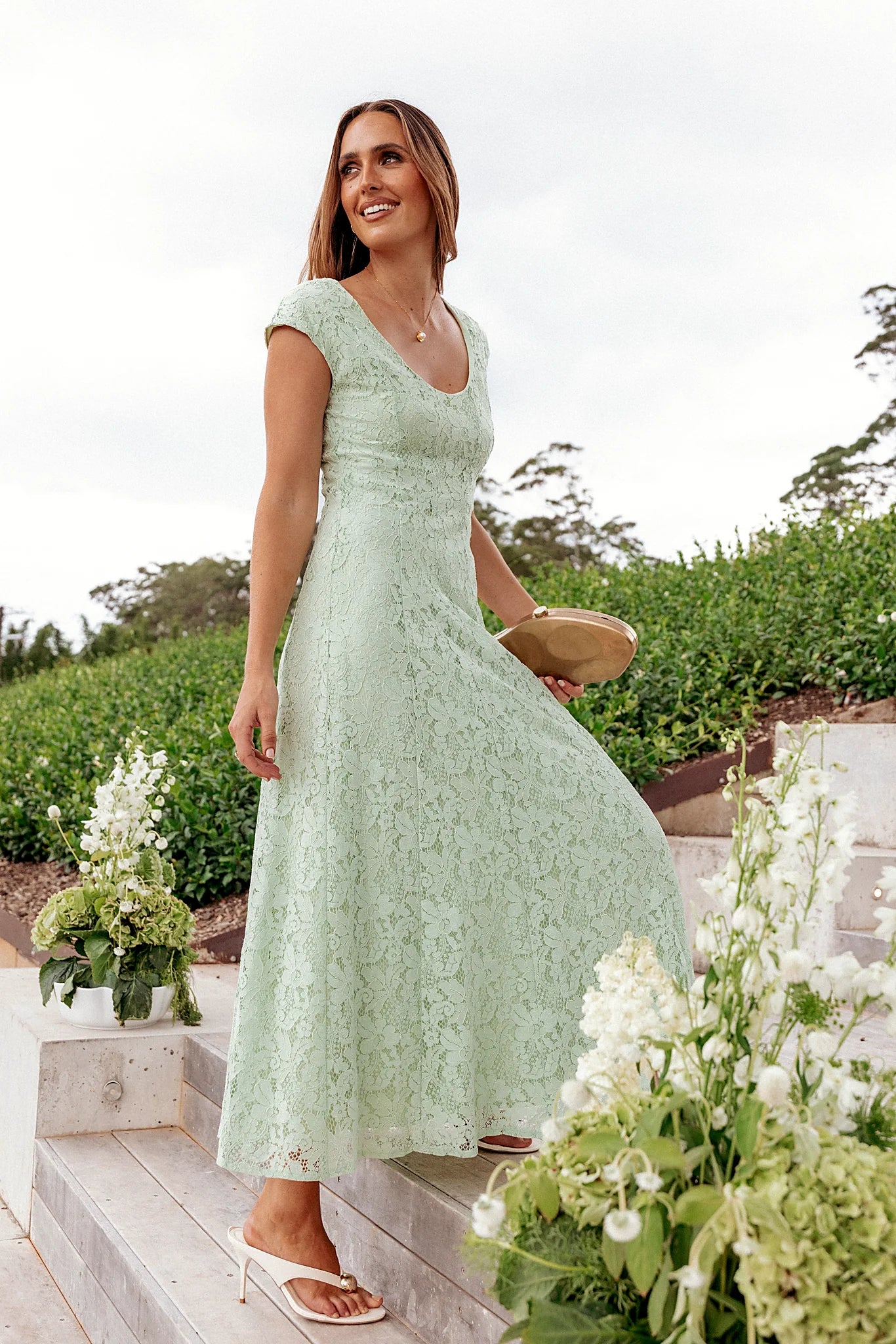 Model wearing the sage green lace maxi dress, front view