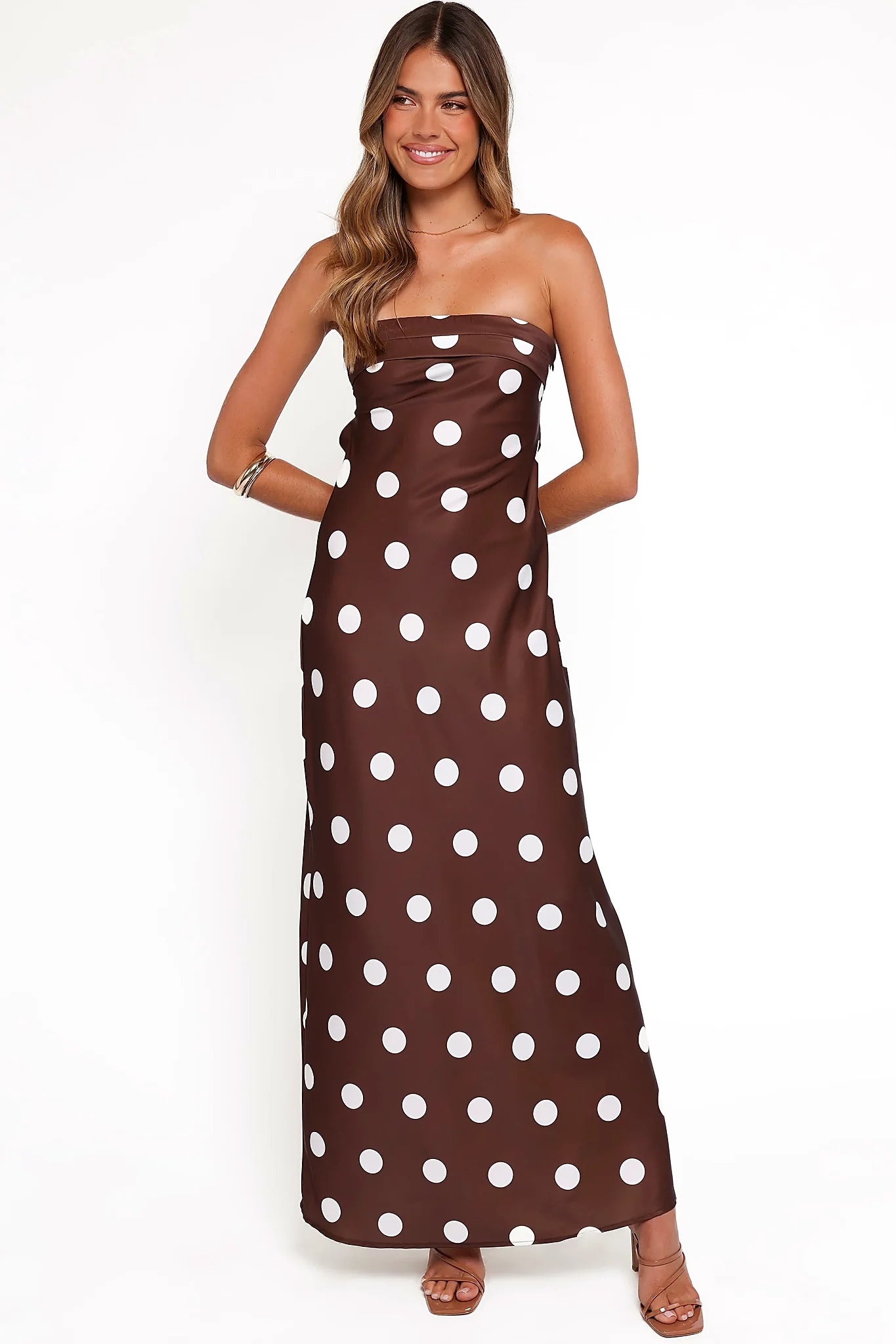 Close-up of the neckline of the brown polka dot strapless maxi dress