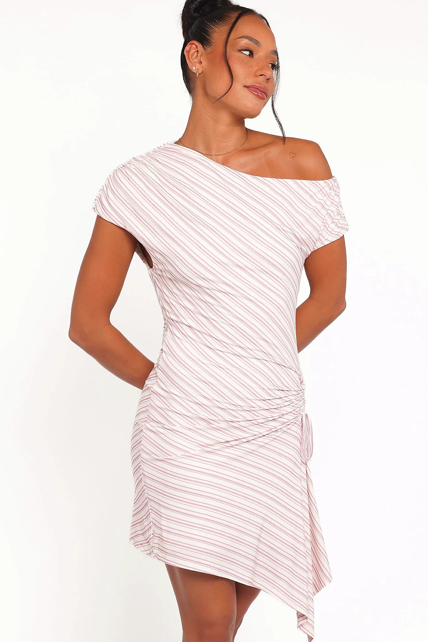 Side view showing the drape of the pink stripe mini dress
