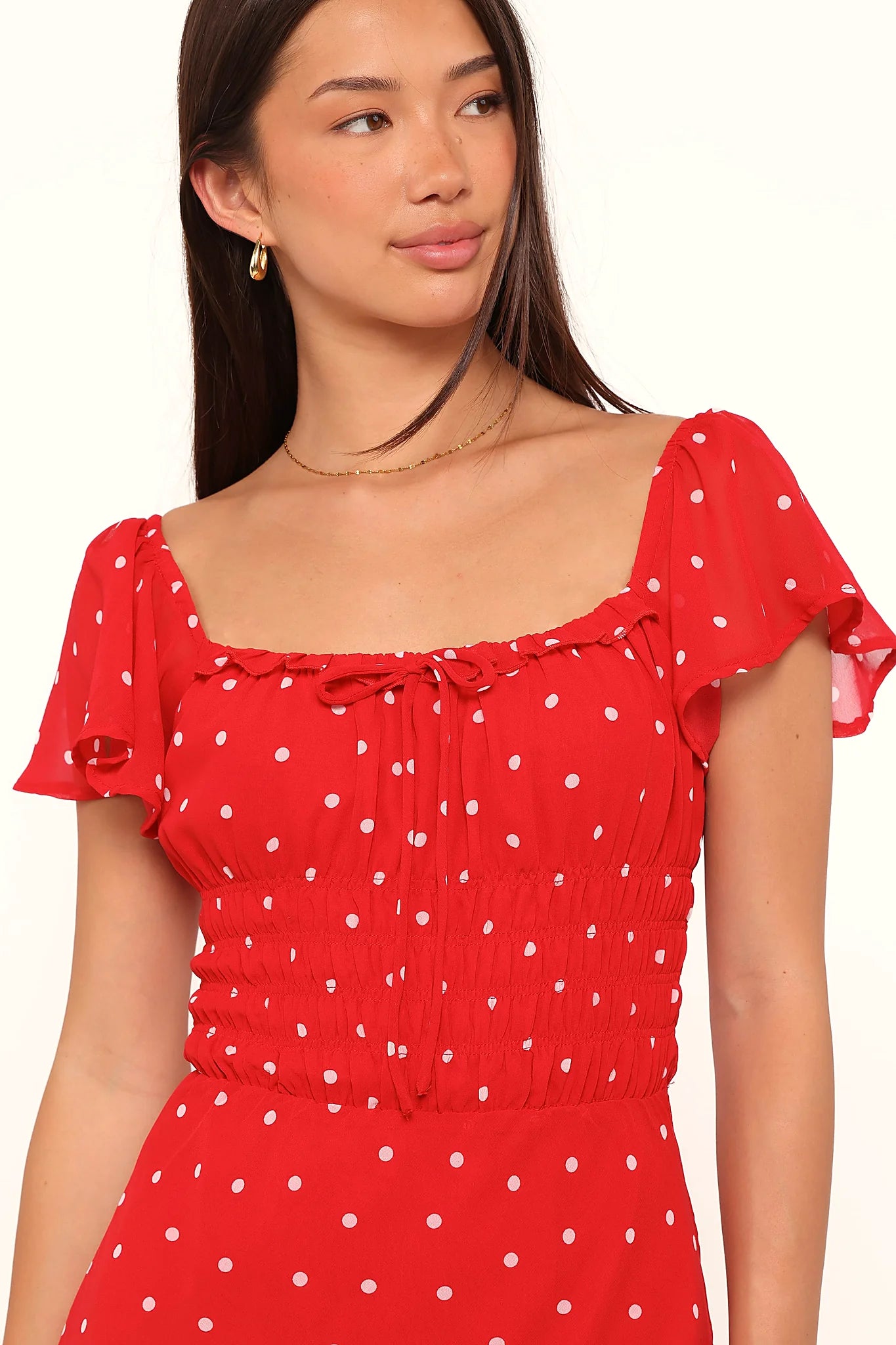Close-up of the neckline of the red polka dot maxi dress