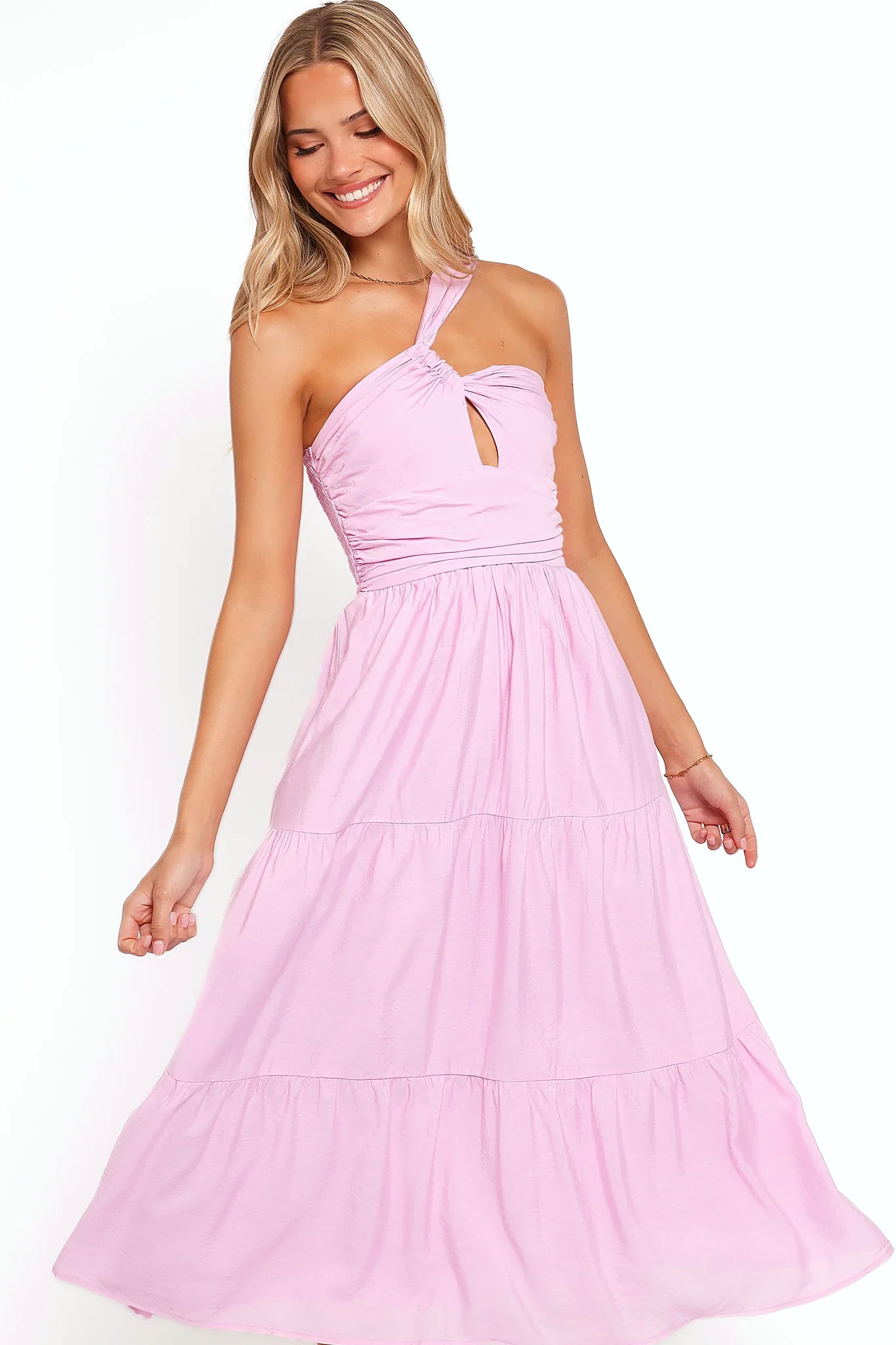 Side view showing the drape of the pink one-shoulder tiered maxi dress