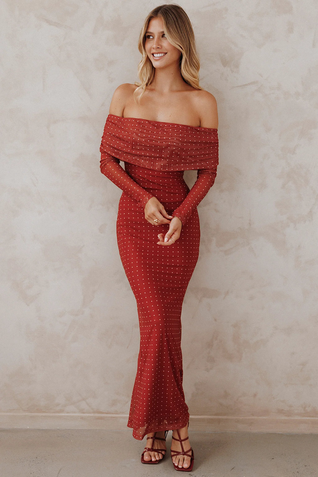 Back view of the burgundy spot off-shoulder maxi dress on a model